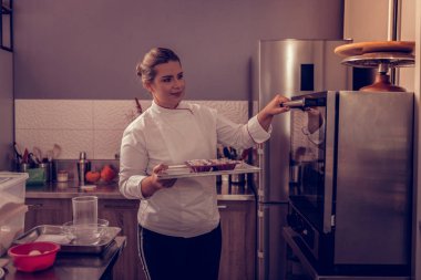 Bir tepsi kurabiye ile tutan güzel genç kadın