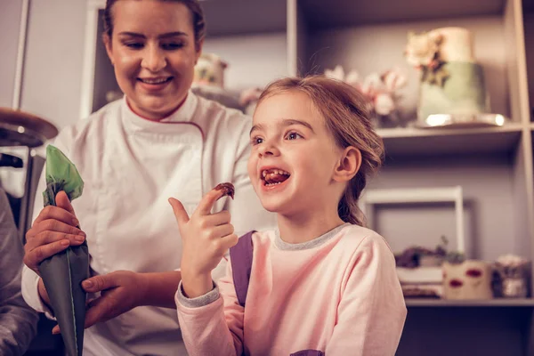 Besten Geschmack Fröhliche Süße Mädchen Lächeln Während Sie Schokoladenteig Genießen — Stockfoto