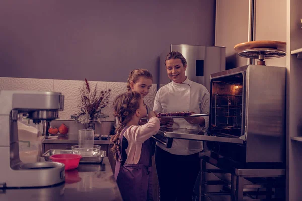 Chicas bonitas positivas ayudando a su madre en la cocina —  Fotos de Stock