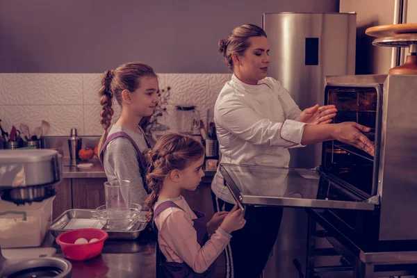 Приємні допитливі дівчата вчаться готувати — стокове фото