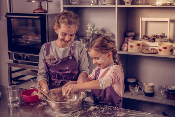 料理をしながら楽しくうれしそうな肯定的な姉妹 — ストック写真