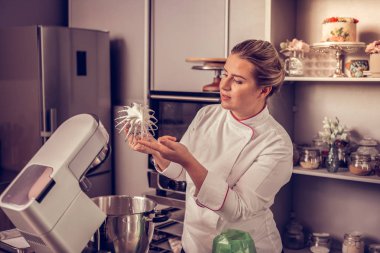 Bir çırpma teli ile krem tutan yetenekli profesyonel şef