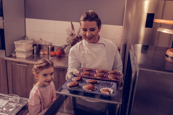 Agréable chef pâtissier qualifié prêt à prendre des muffins — Photo