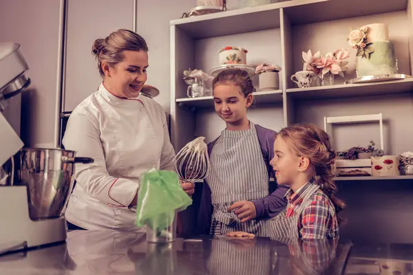 Krem şanti denemek için olumlu neşeli bir kadın — Stok fotoğraf