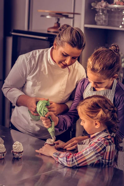 Nice skilled woman holding a pastry bag with cream — Stock Photo, Image