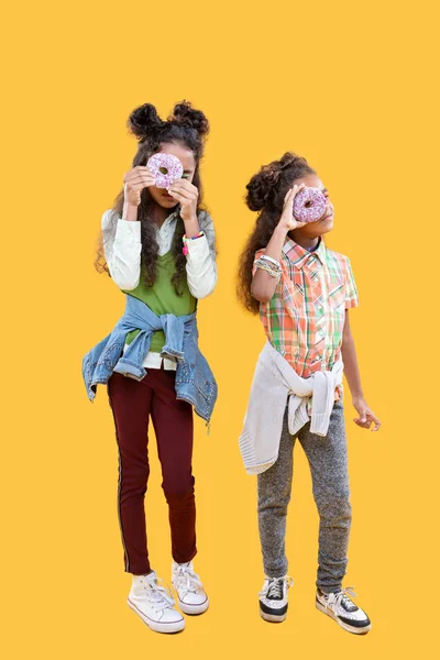 Belle ragazze piacevoli in piedi con le loro ciambelle — Foto Stock