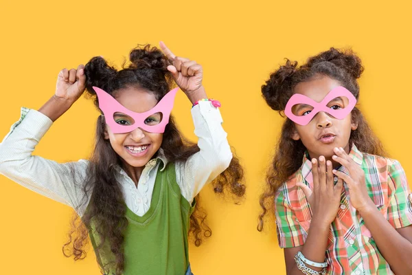 Vrolijke mooie meisjes roze maskers dragen op hun gezicht — Stockfoto