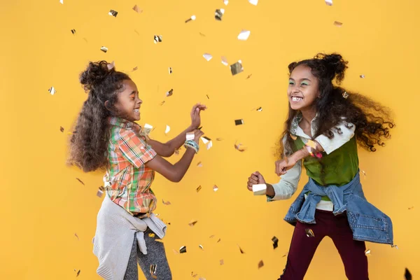 Deleitado chicas positivas jugando con piezas de papel de aluminio —  Fotos de Stock