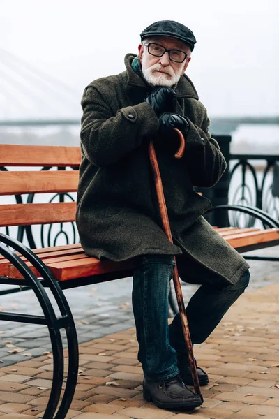 Hombre serio sentado en el banco solo —  Fotos de Stock