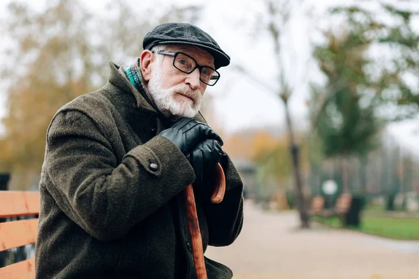 Nadenkende gepensioneerde man leunend op wandelstok — Stockfoto