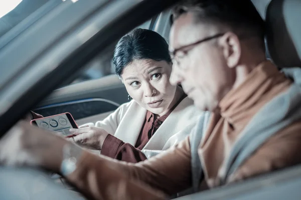 Husband wearing glasses driving while going home with wife — Stock Photo, Image