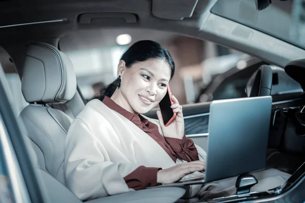 Agradable mujer de negocios sonriente llamando a sus hijos de camino a casa —  Fotos de Stock
