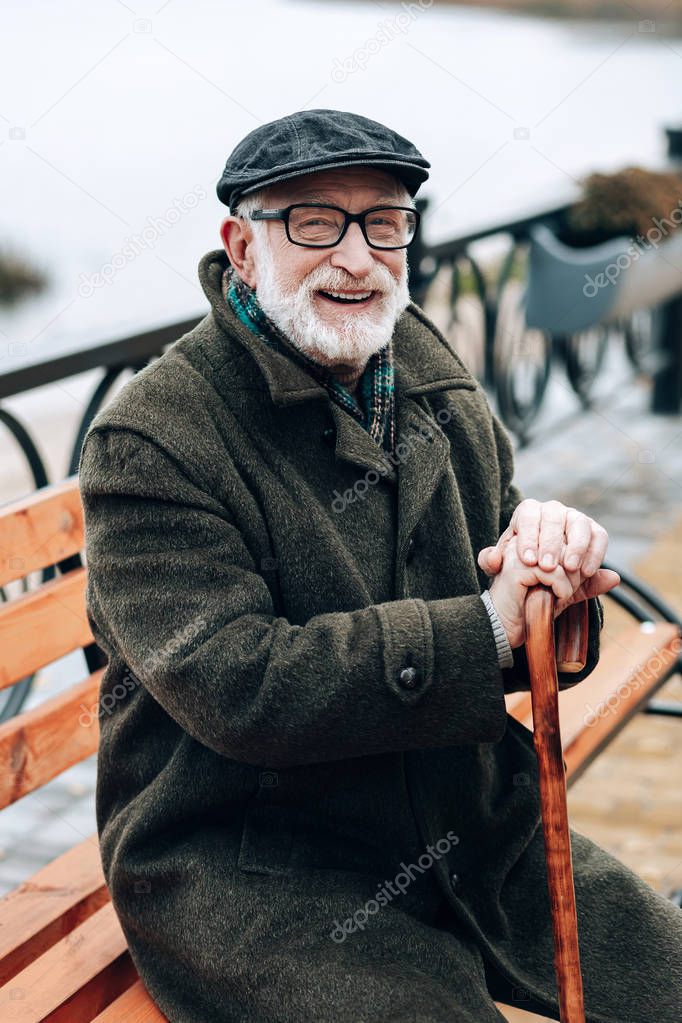 Pleased male person keeping smile on his face