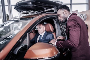 Satın almadan önce yeni yolcu arabasında oturan yakışıklı zengin adam