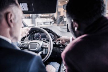 Araba içinde oturan müvekkilinin sözünü sakallı satış müdürü