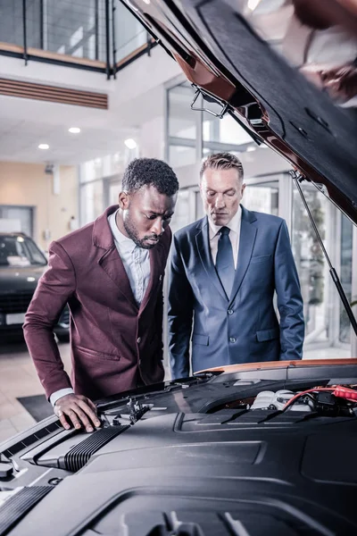 Två eleganta affärsmän bär business klädsel tittar på bilen i salong — Stockfoto