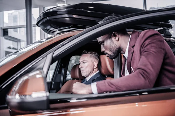 Próspero maduro rico hombre sentado en su nuevo coche de pasajeros — Foto de Stock