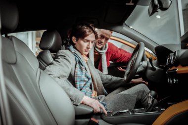 Yeni arabada oturan gri ceket giyen genç şık oğlu