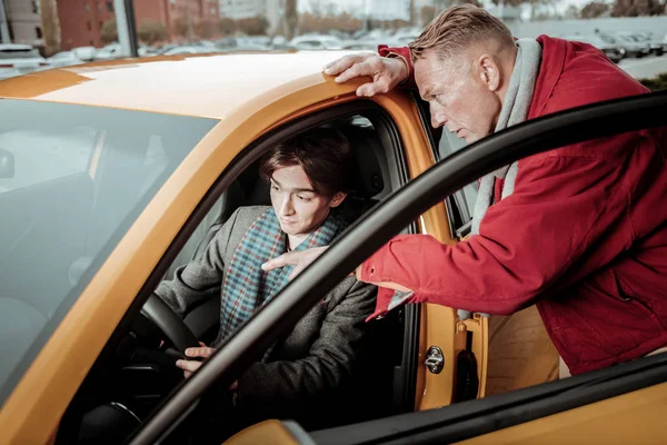 Blonďatá otec pomáhat jeho syn při výběru auta mu — Stock fotografie