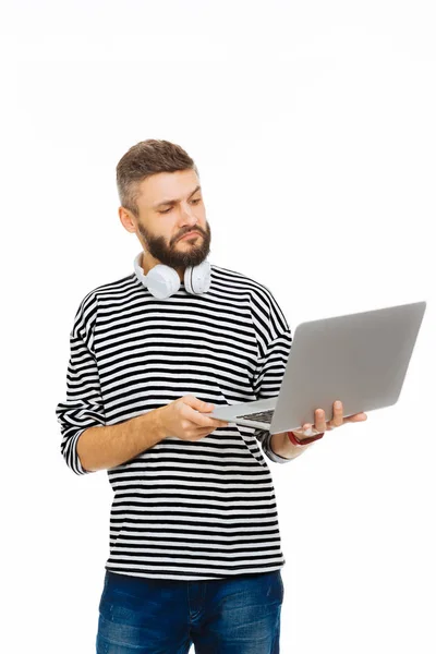 Agradable hombre barbudo mirando la pantalla del ordenador portátil —  Fotos de Stock