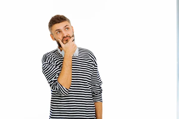 Nice thoughtful young man holding his beard — Stock Photo, Image