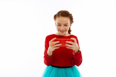 Neşeli pozitif kız onun Smartphone'da oynamaktan