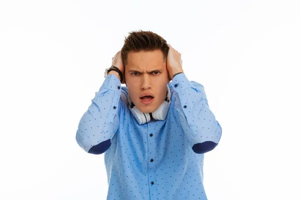 Злой эмоциональный молодой человек закрывает уши — стоковое фото