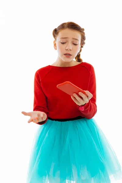 Menina triste agradável olhando para sua tela do telefone — Fotografia de Stock