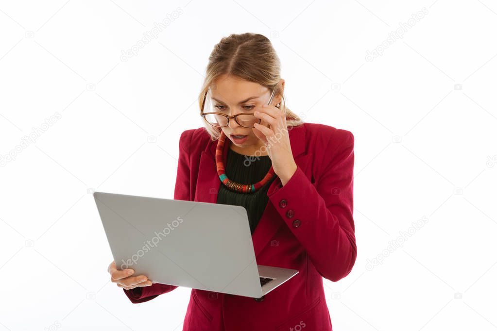 Emotional surprised businesswoman looking at the laptop screen