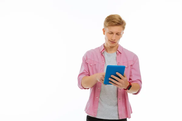 Радостный молодой человек, жмущий планшетный экран — стоковое фото