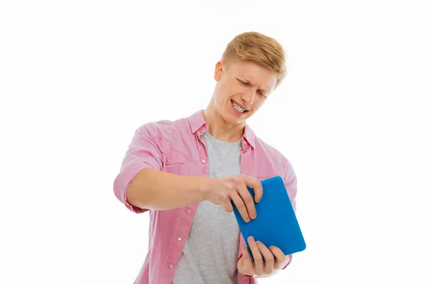 Nice emotional man playing on the tablet Royalty Free Stock Photos