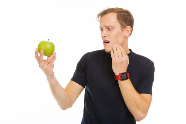 Triste homem sem alegria olhando para a maçã verde — Fotografia de Stock