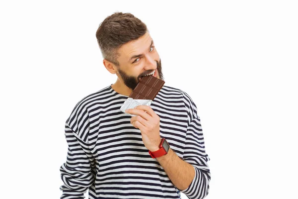 Agradável homem atraente comendo uma barra de chocolate — Fotografia de Stock
