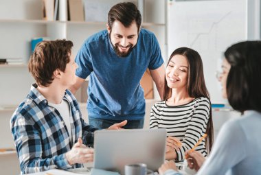 Sakallı Şef. Çalışma ekibi ofiste gelen düz mavi gömlek giymiş siyah saçlı sakallı Şef