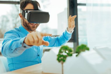 Gülümseyen ve minyatür ağaçlar için işaret eden zeki mühendis