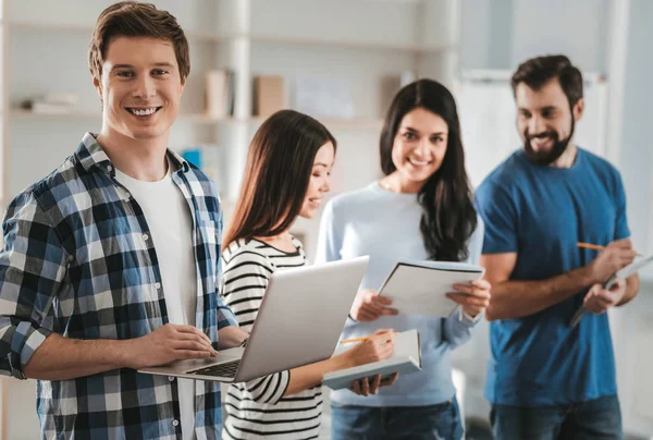 Knappe stralende freelancer met zijn laptop in handen — Stockfoto