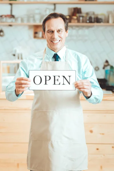 Sonriente hombre de pie con la placa abierta —  Fotos de Stock