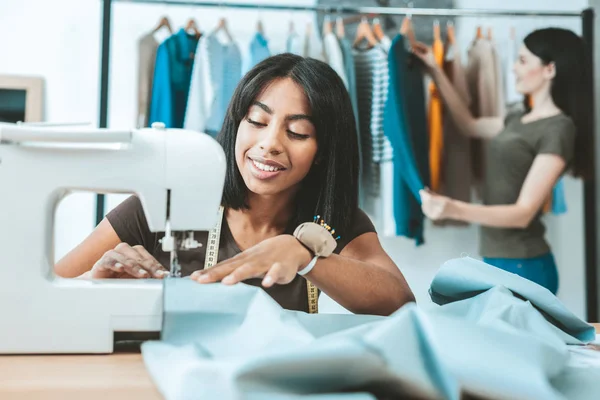 Agradable sentada internacional femenina en el lugar de trabajo — Foto de Stock