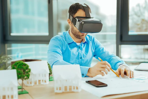 Engenheiro atento sorrindo enquanto trabalhava com óculos de realidade virtual — Fotografia de Stock