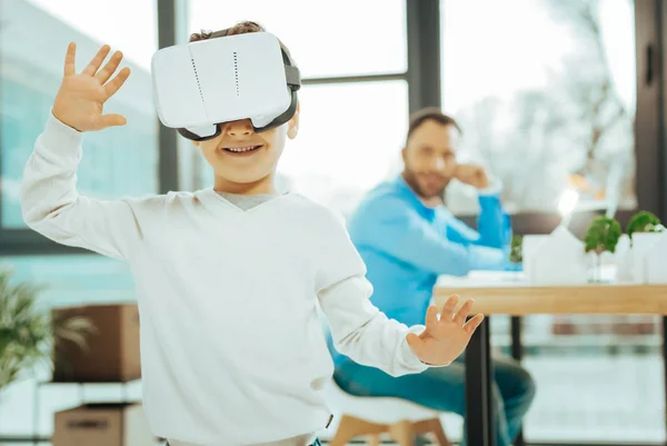 Rapaz inteligente sorrindo enquanto explora a realidade virtual — Fotografia de Stock