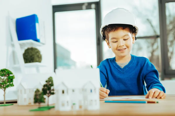 Schöner Junge mit Helm und Zeichnung — Stockfoto