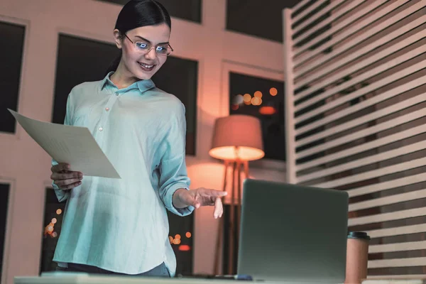 Pleased brunette pointing at computer — Stock Photo, Image