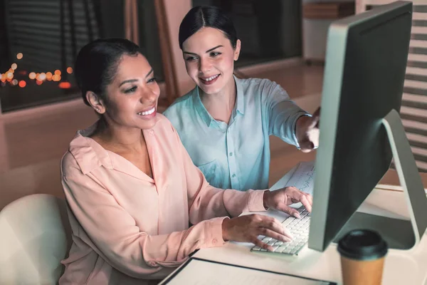 Glada unga kollegor som arbetar vid dator — Stockfoto