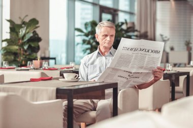 İhtiyar bir kafede bir gazete okuyor