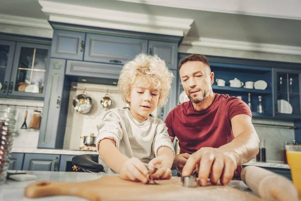 Ernst hübscher Junge und Mann testen Keksformen — Stockfoto