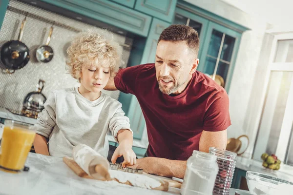 かわいい男の子の父親と一緒にクッキーを焼いたりしながら快適に感じて — ストック写真