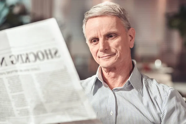 Jó hangulatú nyugdíjas olvasó egy érdekes cikket egy kávézóban — Stock Fotó