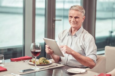 Gülümseyen sosyal medya tablete kullanan adam emekli