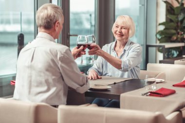 Emekli erkek ve kadın birlikte kırmızı şarap içme