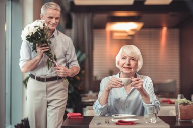Bir kafede bir adamı bekleyerek heyecanlı Bayan